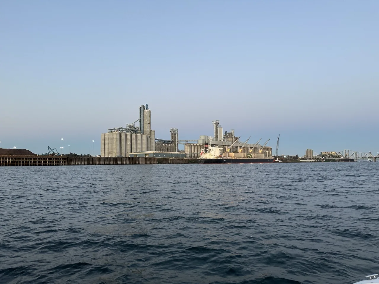 Waterfront bulk terminal with silos, conveyors and a docked vessel